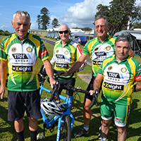 Vision impaired man on left stands with a group of cyclists, all dressed in green and gold