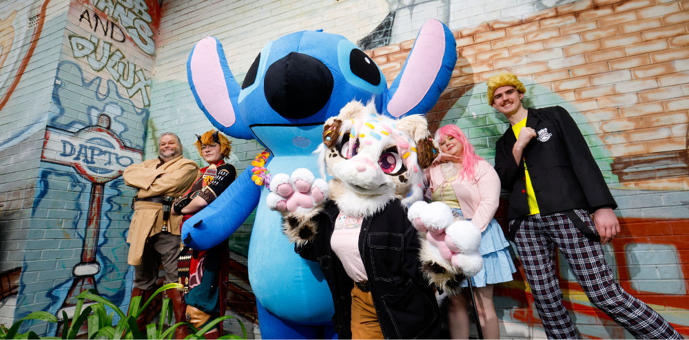Cosplayers standing in front of an iconic mural at Dapto train station to promote Comic Gong 2025