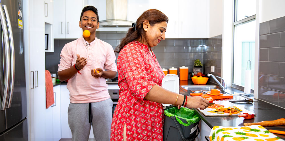 man and woman in kitchen, using FOGO for food scraps